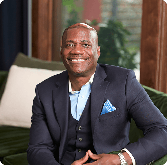 Smiling financial advisor in a suit, seated in a modern office, representing Steele Financial Studios' personalized tax planning services in Atlanta.