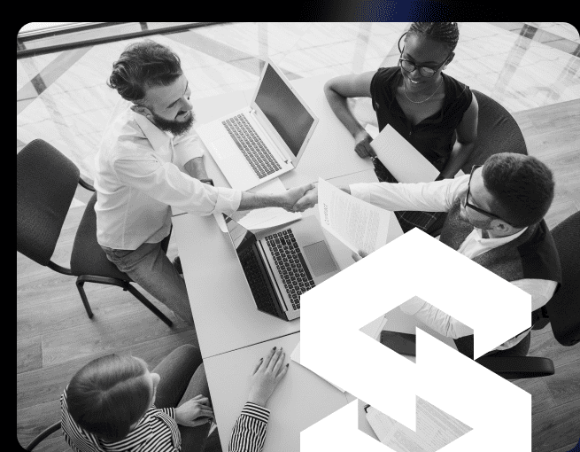 Group of professionals engaged in a business meeting, discussing financial strategies, with laptops and documents on the table, emphasizing collaboration and planning for long-term financial success.